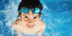 boy in a pool looking up at camera