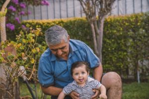 grandfather and toddler grandson in a garden