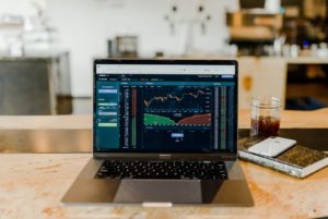 photo of a laptop in a coffee shop displaying stocks