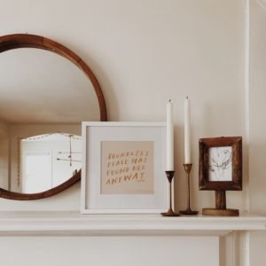 picture of a mantle with a few wooden and white decorations