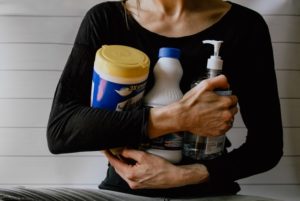 picture of the torso of a woman holding cleaning products