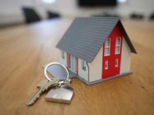 small toy house on desk with keys beside it