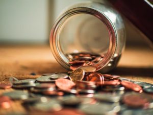 picture of a jar of pennies and coins spilling out of a jar