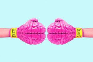 picture of two boxing gloves that look like pink brains facing each other