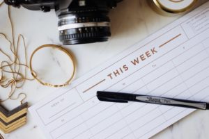 picture of items on a desk a mini calendar camera and bracelet