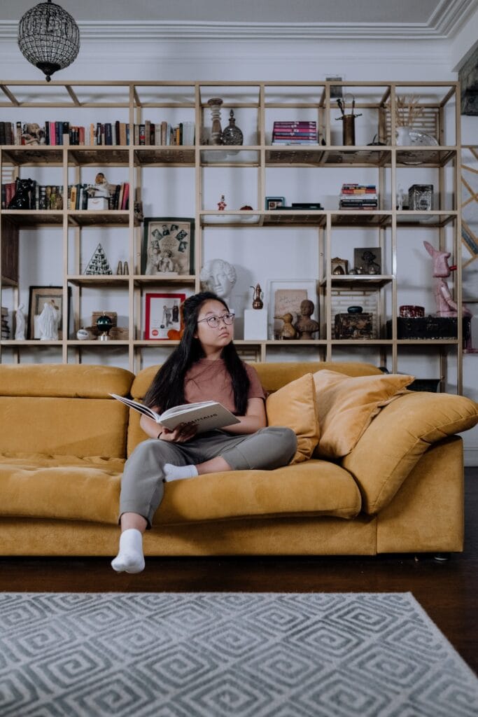 picture of a girl on a comfortable couch that is yellow