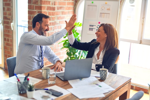 happy co-workers high-fiving