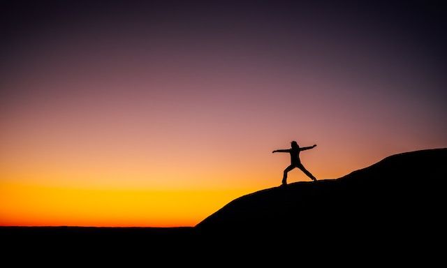 person standing on top of mountain at sunrise