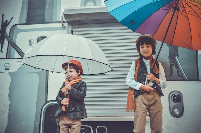 two kids holding umbrellas