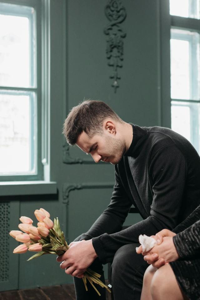 man sitting with flowers