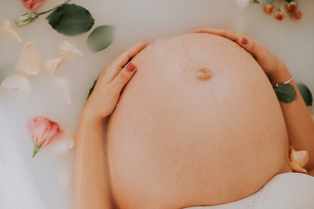 woman's pregnant belly in milk bath