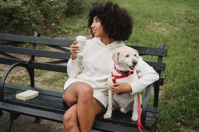 woman sitting on bench with dog