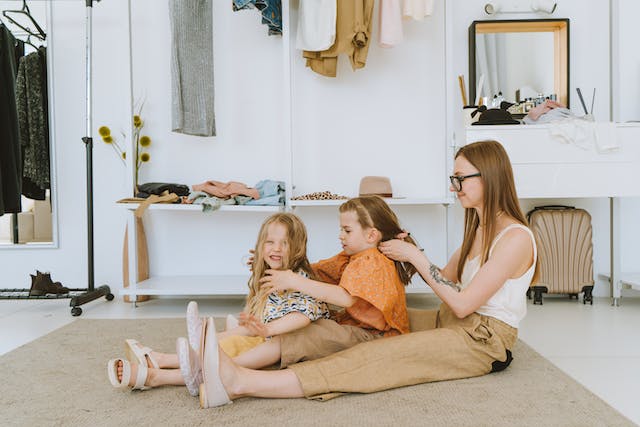 mom and daughters braiding hair