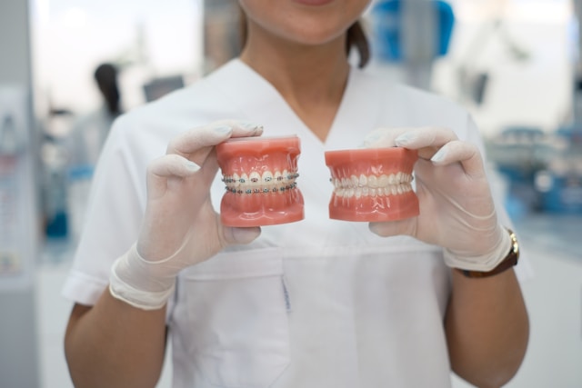 dentist holding fake teeth