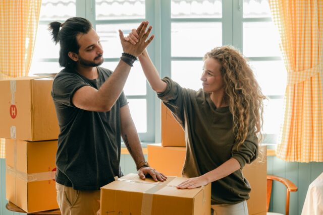 couple high-fiving while packing boxes