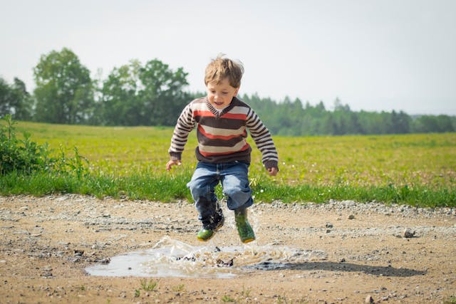 boy jumping in puddle