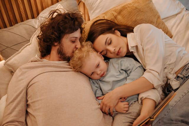 mom, dad, and son in bed