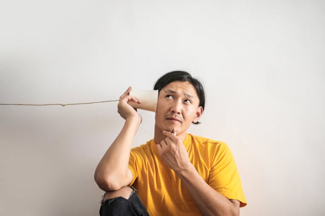 man listening in cup