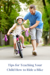 dad helping daughter ride bike