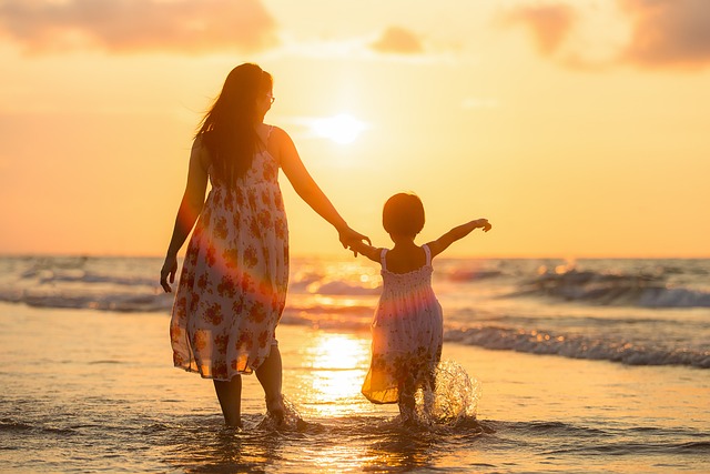 Mother and daughter at beach for sunset