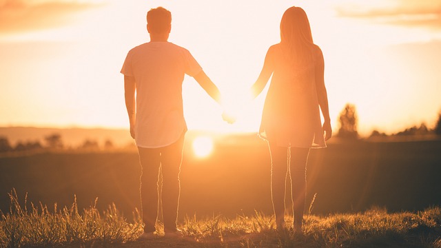 couple holding hands at sunset