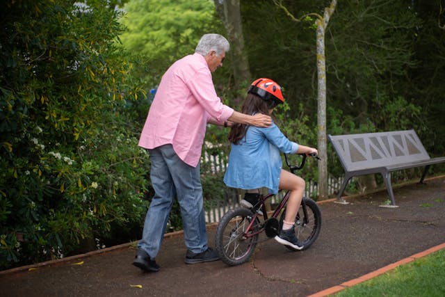 dad helping daughter ride bike
