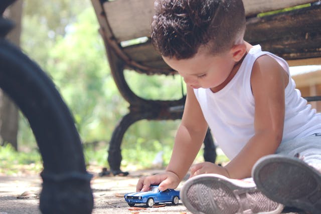 boy playing with blue car