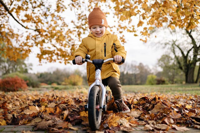 boy riding bike in leaves