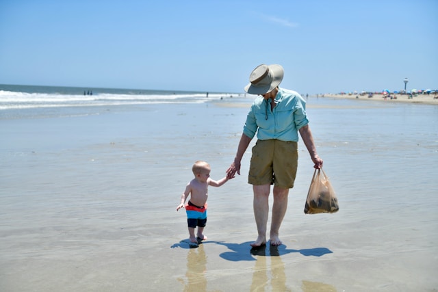 grandpa and grandson walking on beach