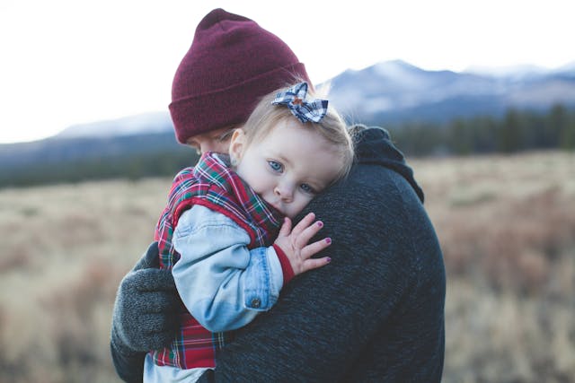 father hugging toddler outside