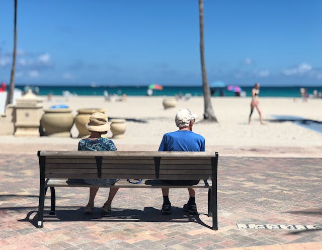 senior couple on park bench at beach