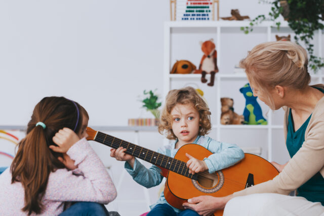 child playing a guitar at school