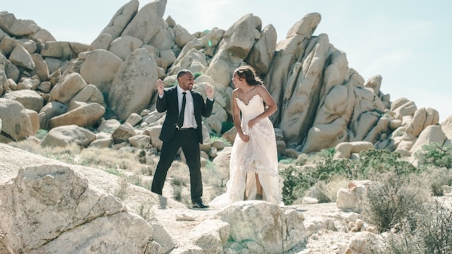 bride and groom laughing standing on top of mountain