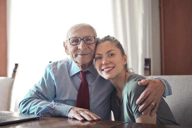 young woman hugging older senior citizen man