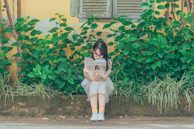 girl reading book outside