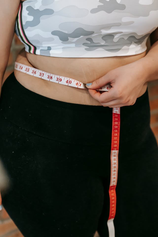 woman measuring her stomach, weight loss