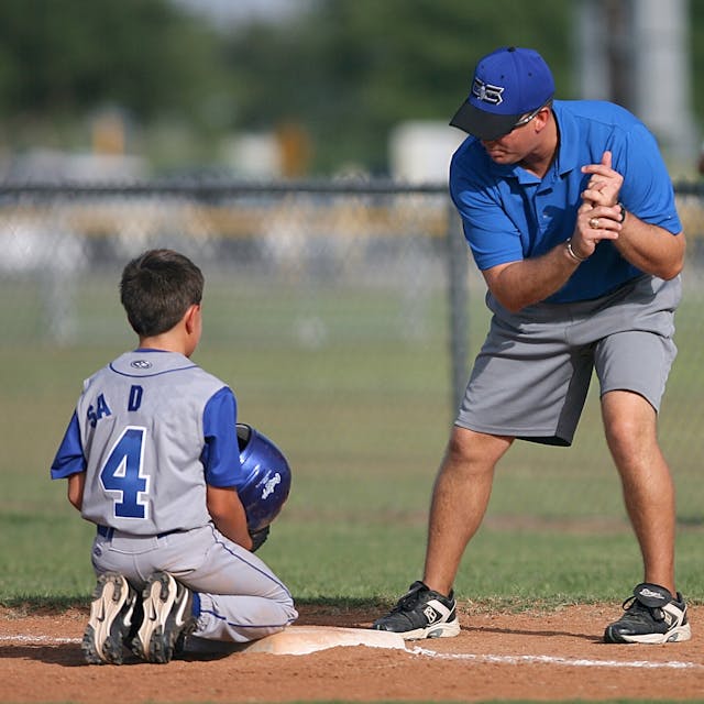 kid baseball player with coach