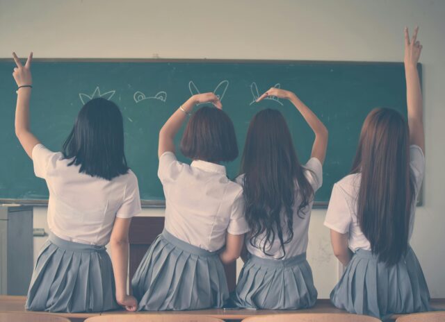 4 girls at school in front of chalk board
