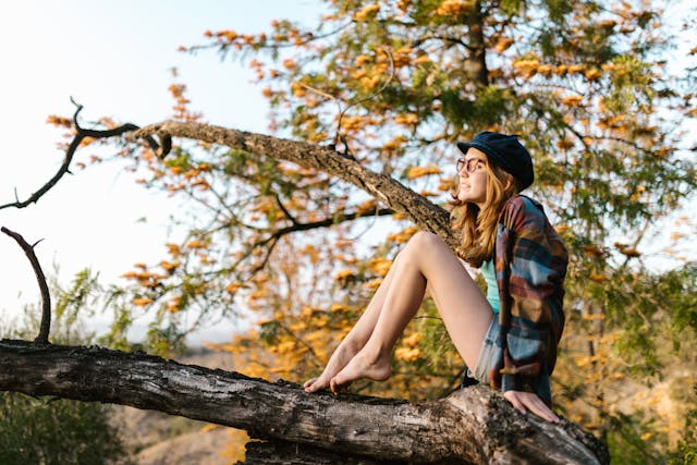 teen girl sitting on tree branch