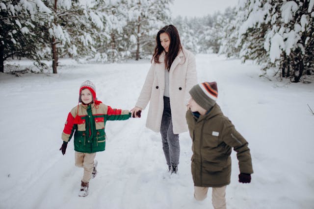 mom with 2 boys bundled up out in snow