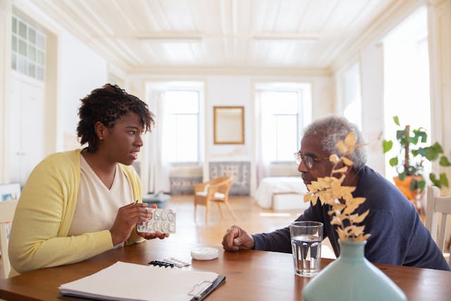 young woman sitting across from the table of older man