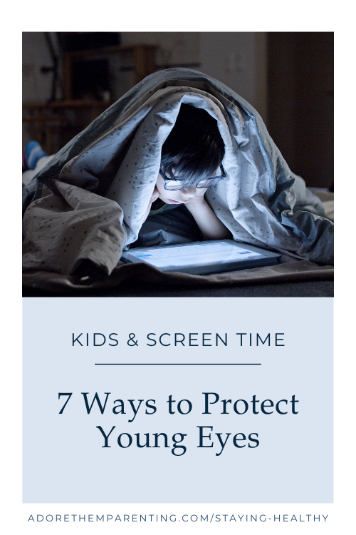boy looking at screen under blankets