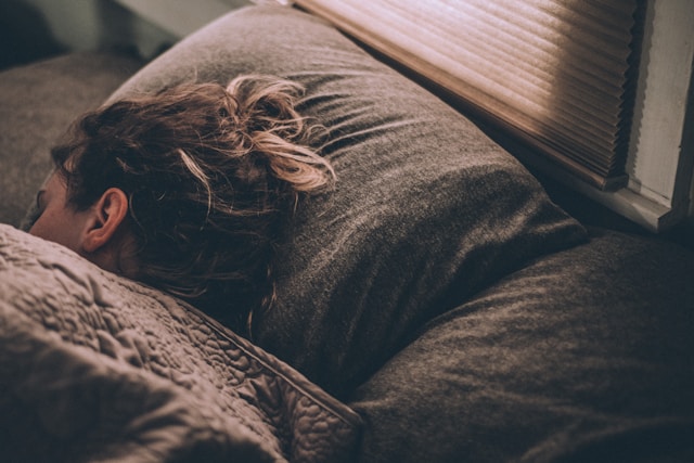 woman sleeping on brown sheets