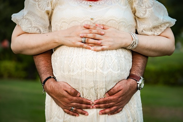 pregnant woman with her and husbands hands on belly