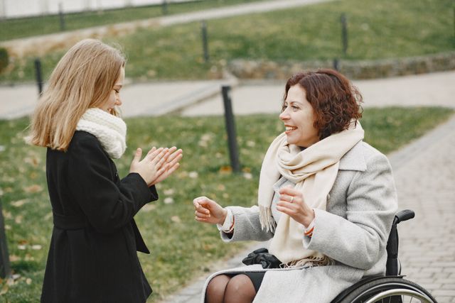 2 women talking, one in a wheelchair