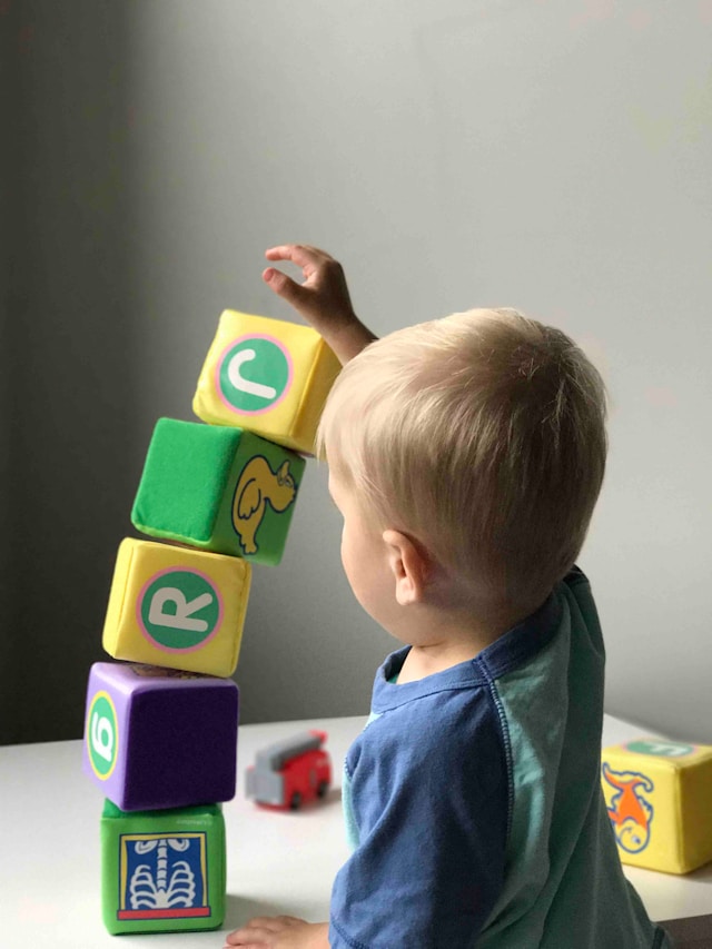 toddler boy stacking blocks