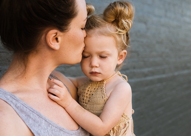 mom kissing daughter