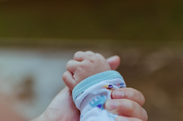 baby holding parent's hand