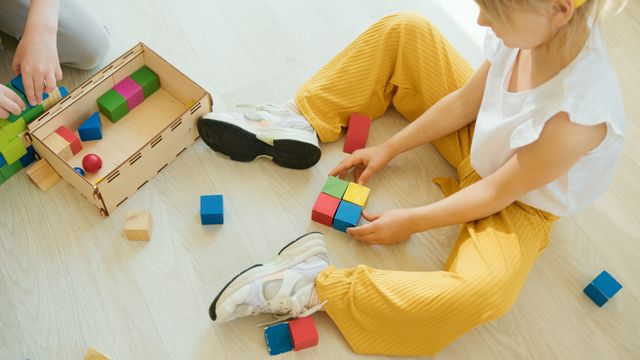 child sitting on floor playing with toys